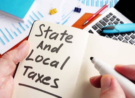 A journal with state and local taxes written in it with a thick marker